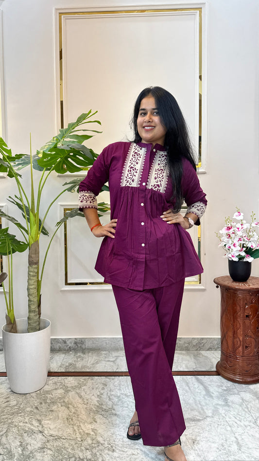 Woman wearing a wine purple A-line kurti with cream floral print yoke and matching palazzo